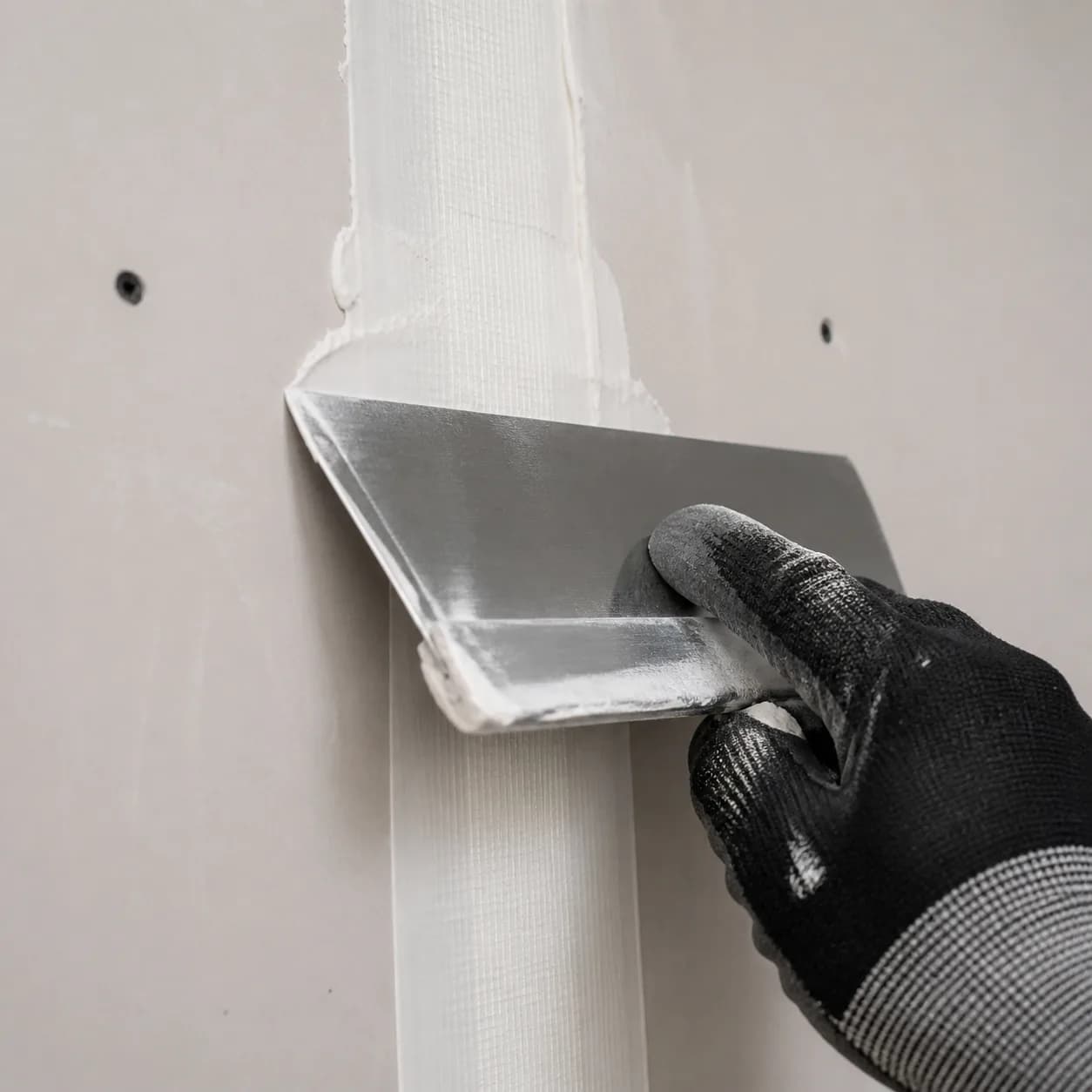 Aplicação de fita e massa na junta de placas de drywall